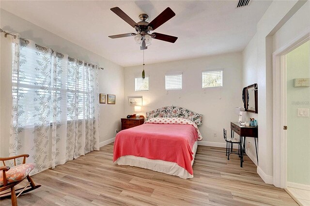 bedroom featuring visible vents, baseboards, light wood-style floors, and a ceiling fan