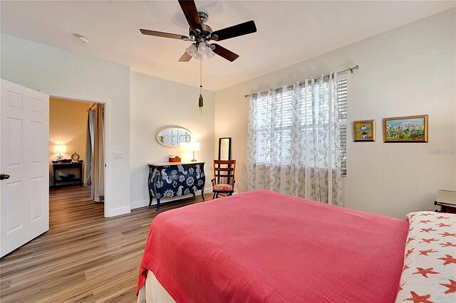 bedroom with baseboards, wood finished floors, and a ceiling fan