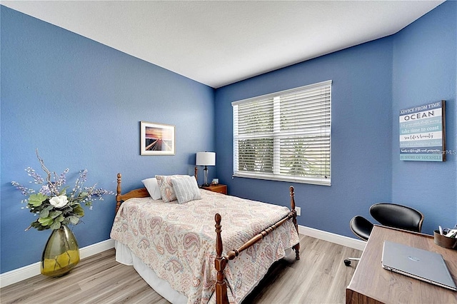 bedroom with wood finished floors and baseboards