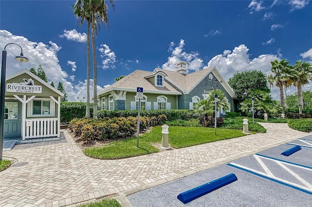 view of front of house with a front lawn and uncovered parking