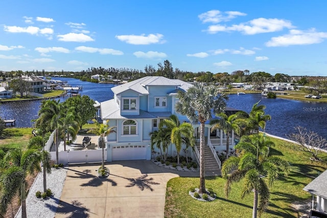 view of front of property with a water view, stairway, a garage, driveway, and a gate