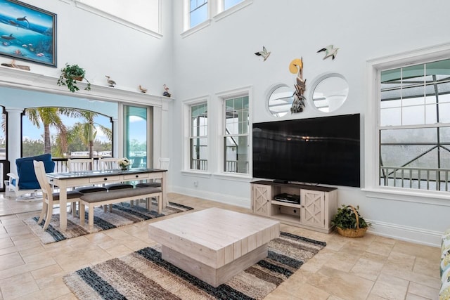 living room featuring baseboards and a towering ceiling