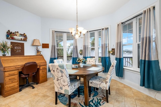 dining space with an inviting chandelier and baseboards