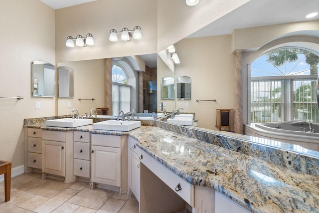 bathroom featuring double vanity, walk in shower, a bath, and a sink