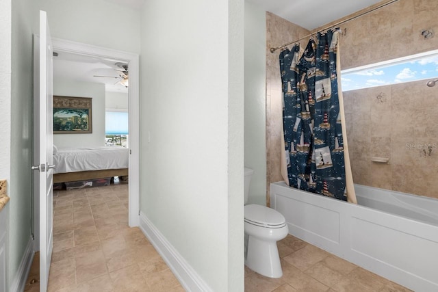 ensuite bathroom featuring connected bathroom, baseboards, ceiling fan, toilet, and shower / tub combo