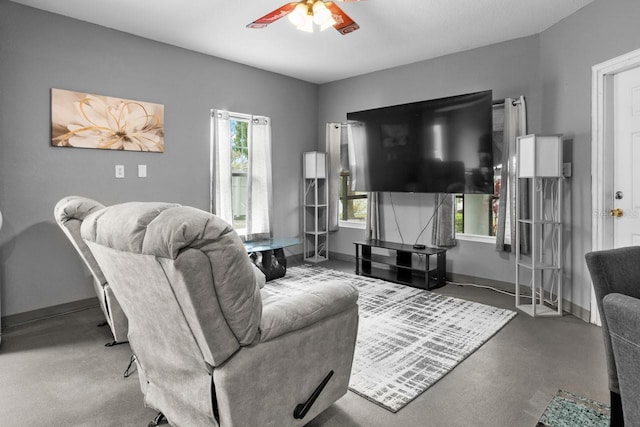 living room featuring baseboards and ceiling fan