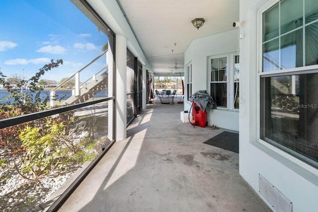 sunroom featuring visible vents and a water view