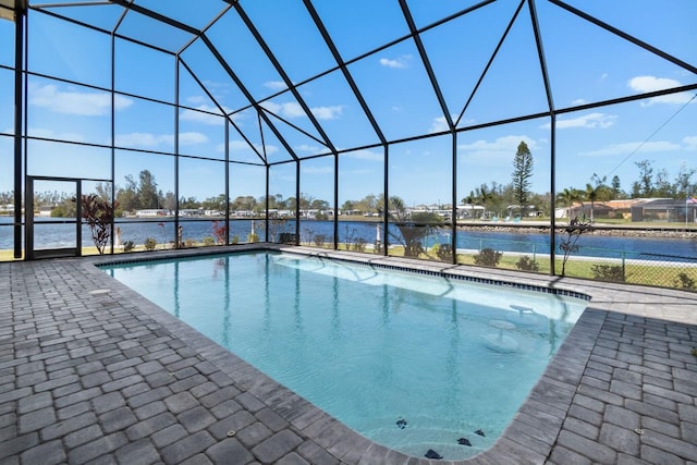 outdoor pool featuring glass enclosure and a patio