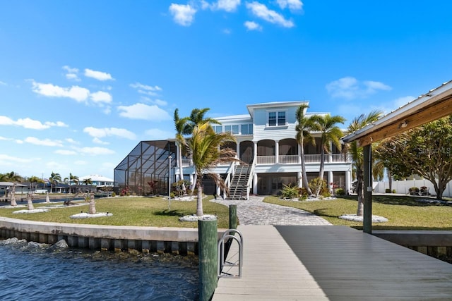 back of house featuring stairs, a lawn, a water view, and driveway