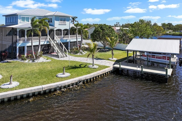 view of dock with stairway, a yard, a water view, and boat lift