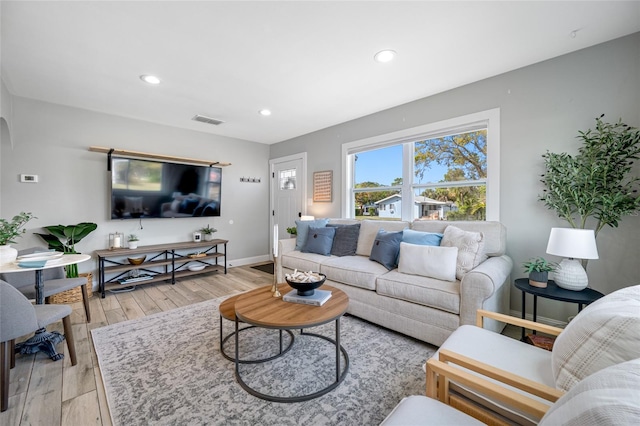 living room with light wood-type flooring, baseboards, visible vents, and recessed lighting