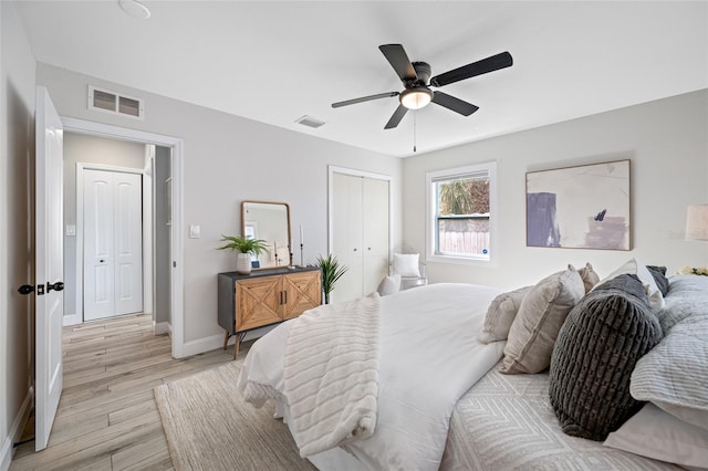 bedroom with a closet, visible vents, light wood-style flooring, and baseboards