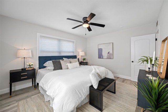 bedroom with light wood-type flooring, visible vents, baseboards, and a ceiling fan