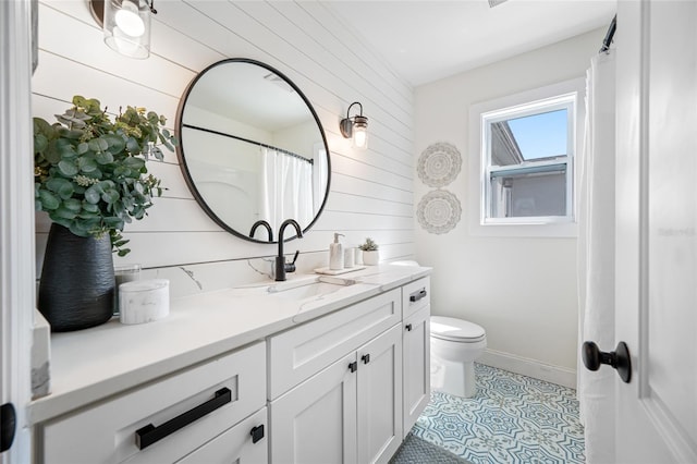 full bathroom featuring baseboards, toilet, tile patterned floors, vanity, and wood walls