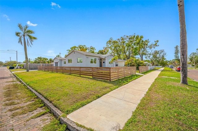 view of front of property featuring a fenced front yard and a front lawn