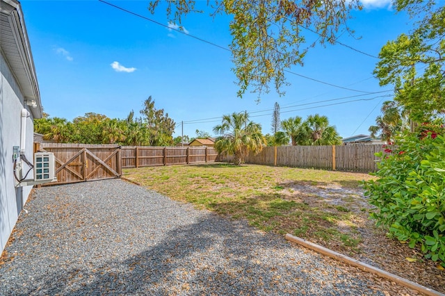 view of yard with a fenced backyard and a gate