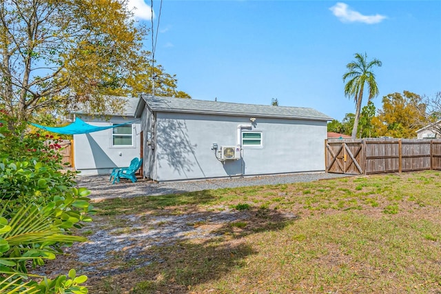 back of property with fence, a lawn, and stucco siding