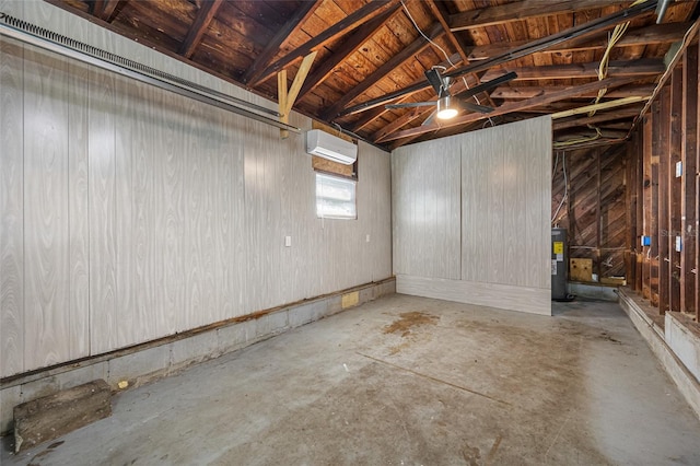 below grade area with a garage, a wall mounted air conditioner, and electric water heater