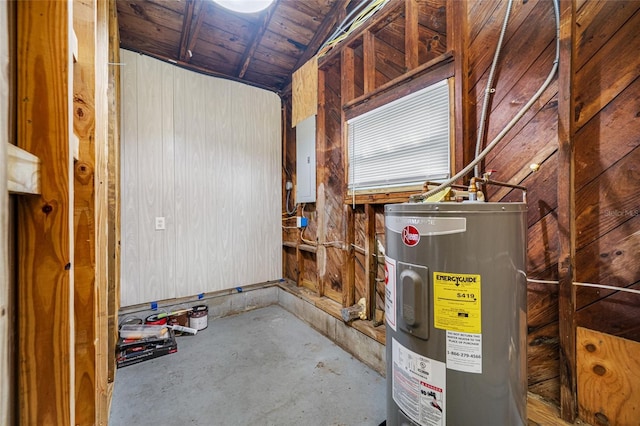 utility room featuring electric panel, a garage, and water heater