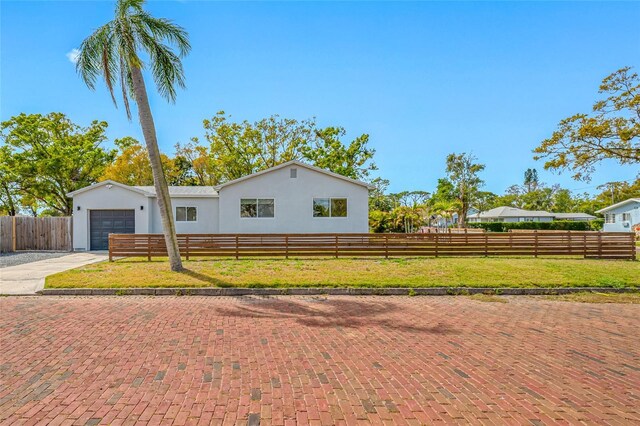 view of front of property featuring a fenced front yard, decorative driveway, and stucco siding