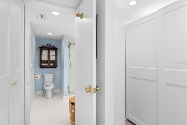 full bath featuring tile patterned flooring, toilet, visible vents, baseboards, and walk in shower