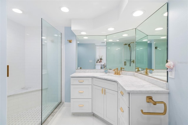 bathroom with recessed lighting, tiled shower, and vanity