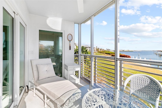 sunroom featuring a water view