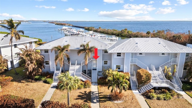 view of front of home with a water view, stairway, and metal roof