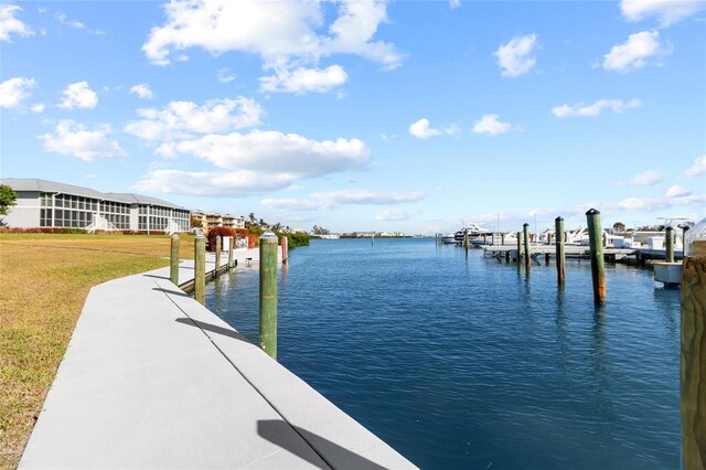 dock area with a lawn and a water view