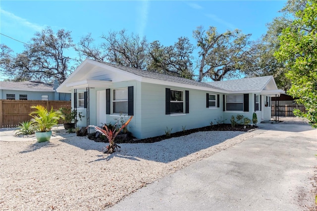 ranch-style house featuring fence