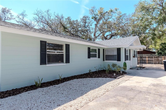 exterior space with roof with shingles and fence