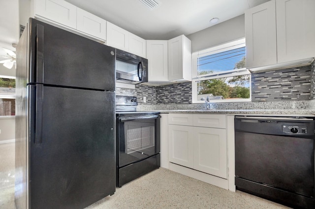 kitchen featuring visible vents, backsplash, black appliances, white cabinetry, and a sink