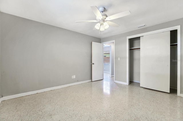 unfurnished bedroom featuring baseboards, visible vents, a ceiling fan, speckled floor, and a closet