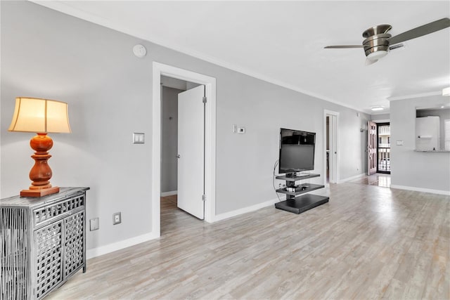 living room with ornamental molding, light wood-type flooring, baseboards, and a ceiling fan