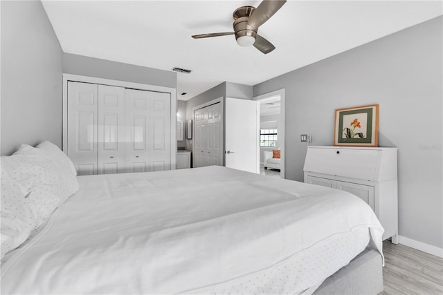 bedroom with light wood-type flooring, visible vents, ceiling fan, and baseboards