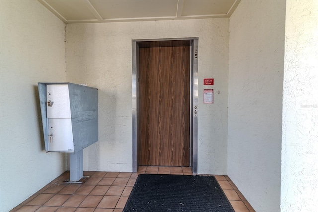 entrance to property with elevator and stucco siding