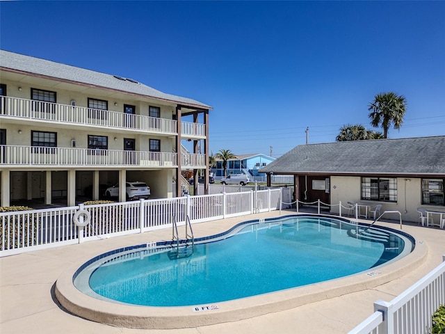 community pool with fence and a patio