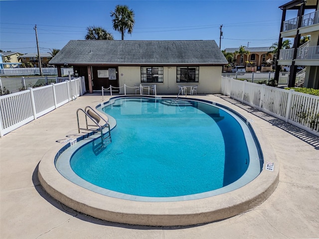 community pool featuring a patio area and a fenced backyard