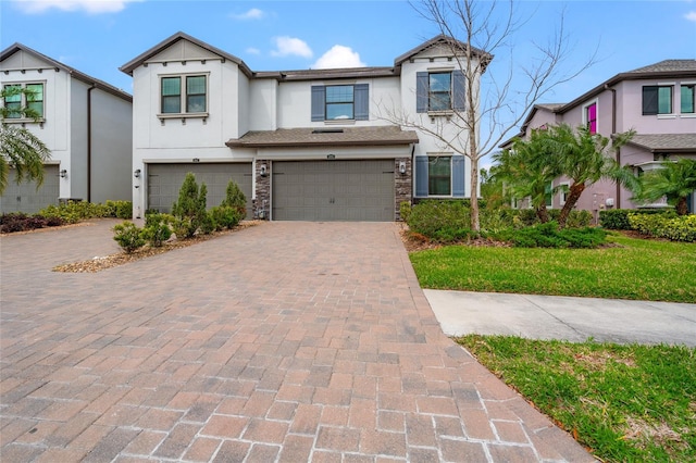 view of front of property featuring a garage, decorative driveway, and stucco siding