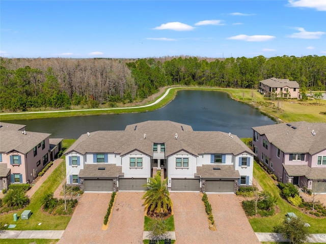 birds eye view of property featuring a residential view, a water view, and a wooded view