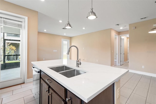 kitchen with decorative light fixtures, a sink, light countertops, dark brown cabinets, and stainless steel dishwasher