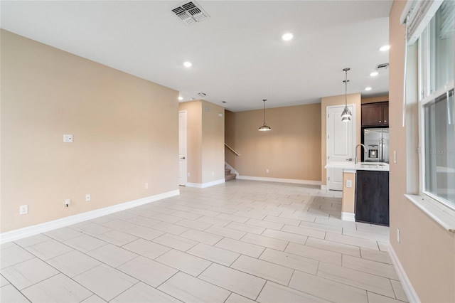 unfurnished living room with stairway, recessed lighting, visible vents, and baseboards