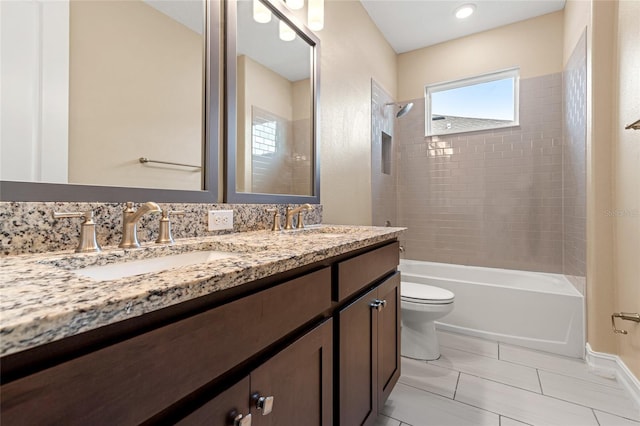 bathroom featuring double vanity, a sink, toilet, and shower / bathtub combination