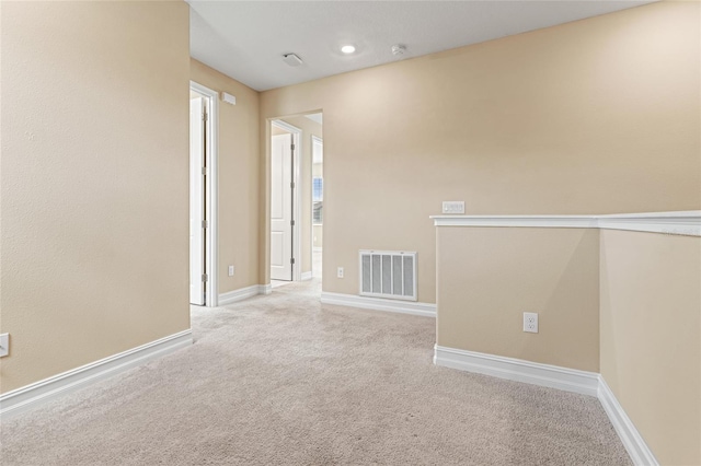 unfurnished room featuring carpet, visible vents, and baseboards