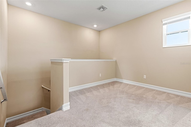 carpeted spare room with baseboards, visible vents, and recessed lighting