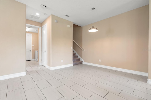 spare room featuring visible vents, stairway, and baseboards