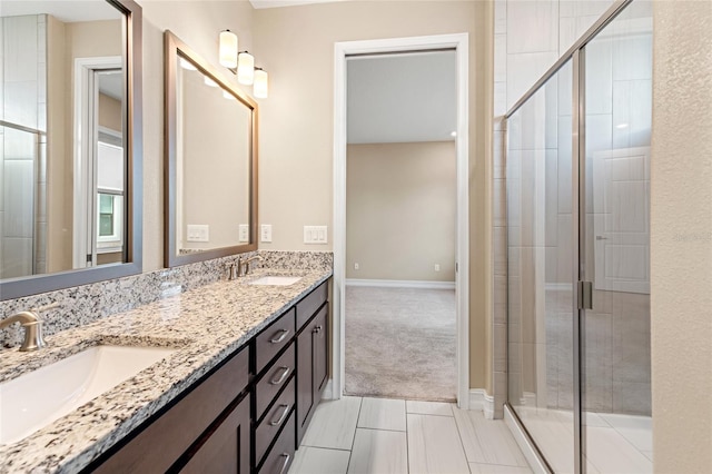 full bathroom featuring double vanity, a stall shower, and a sink