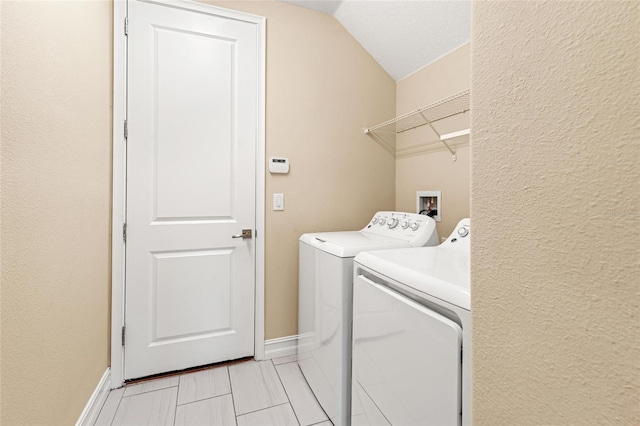 washroom with laundry area, baseboards, and washer and dryer