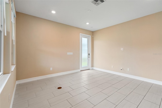 spare room with recessed lighting, visible vents, and baseboards