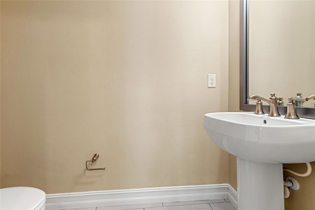 bathroom with toilet and baseboards